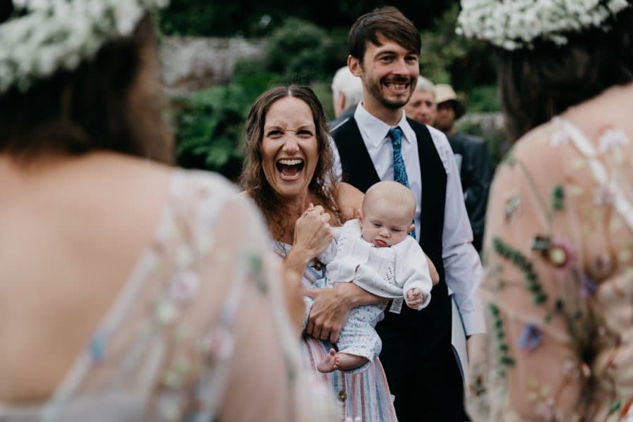 laughing wedding guest holding baby
